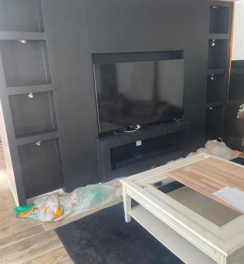 Peinture mate et installation des rangements muraux Finition noire élégante, contrastes nets avec les étagères.