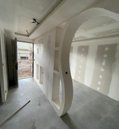 Avant travaux – cloison courbe en cours de création Structure placo et niches décoratives intégrées.